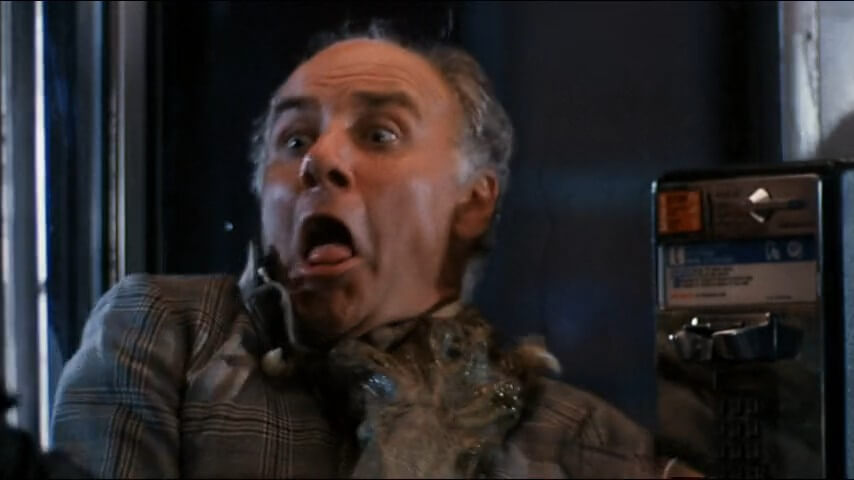 A monstrous hand grips the throat of a terrified man.