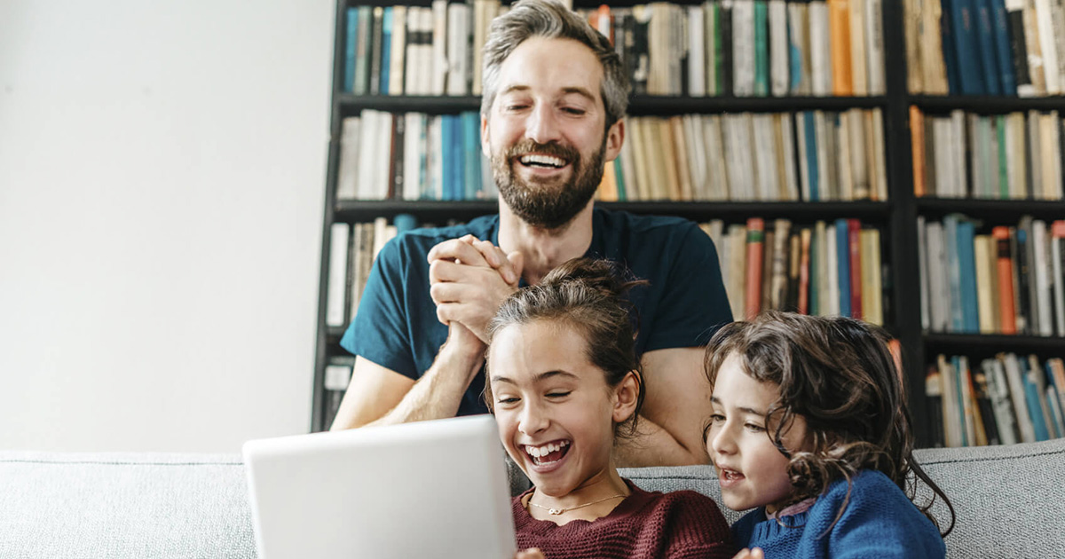 family laughing around a computer screen