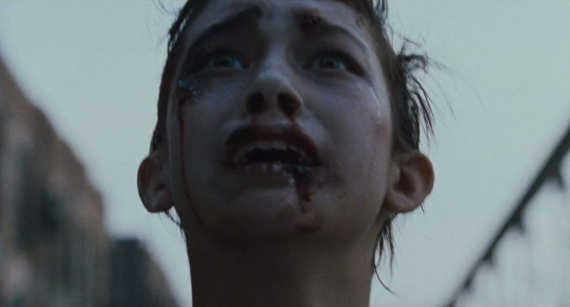 A close-up shot of a wild-eyed, fleeing young woman.