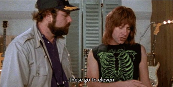 Two men stand discussing a Marshall amplifier.