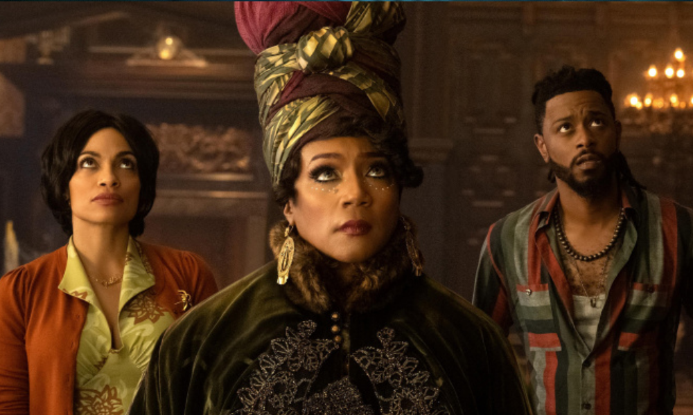 A woman and a man stand behind a spirit medium, each looking at something behind the camera with an apprehensive expression.