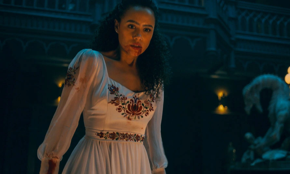 A woman wearing a white dress with a red substance at her mouth.