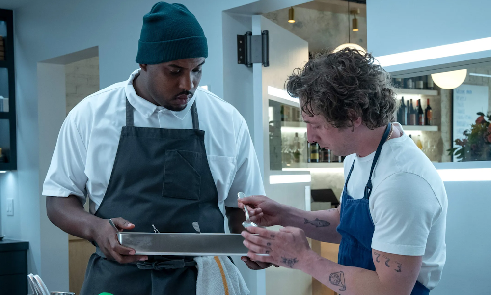 Two men in aprons test a dish in The Bear's kitchen.