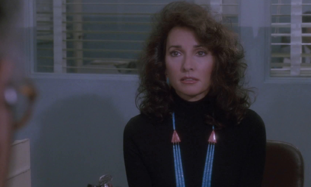 A woman with a big '80s hairstyle looking worried.