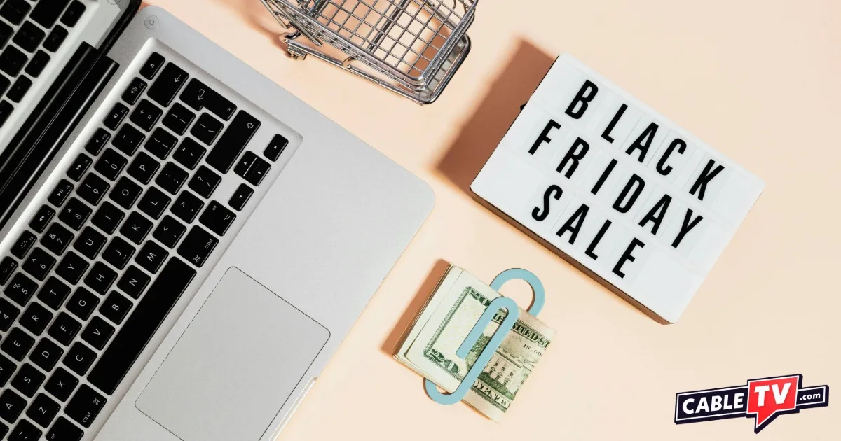 Overheard image of laptop keyboard on a table with $20 bill and note card reading Black Friday Sale