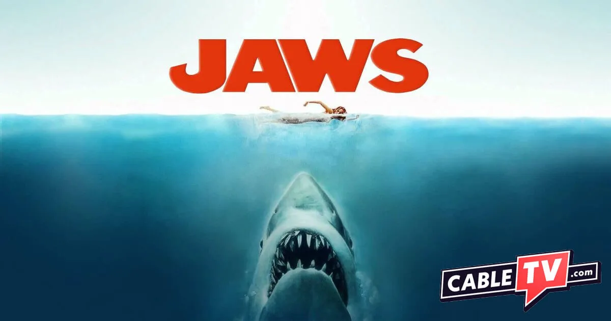 The iconic image of a massive shark swimming up toward an unsuspecting swimmer. The word JAWS hovers above the victim.