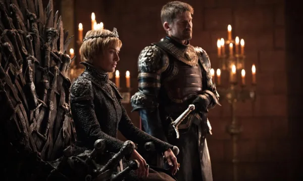 Cersei from Game of Thrones sits on a throne with short hair with her brother standing next to her.