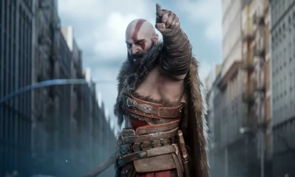 Kratos, a bald man with red face paint and a beard, pointing.