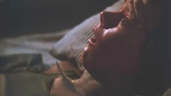 Image of Kevin Bacon as an unseen attacker kills him from under his bunk in Friday the 13th (1980).