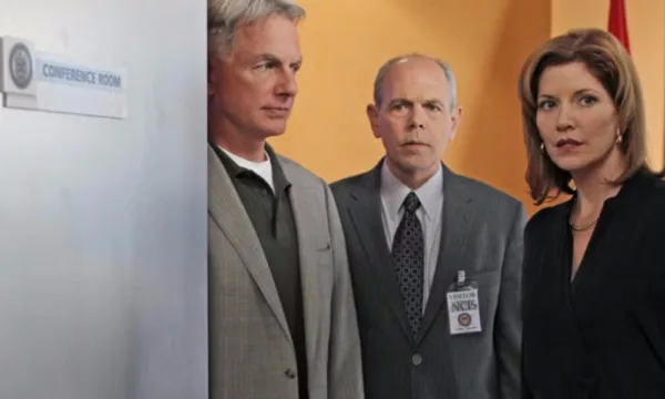 Three NCIS characters (two gray-haired men and a woman) look at something offscreen.