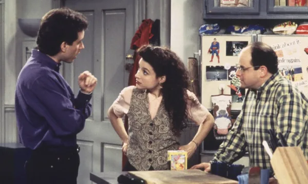 Jerry, Elaine, and George from Seinfeld stand around talking in the kitchen.